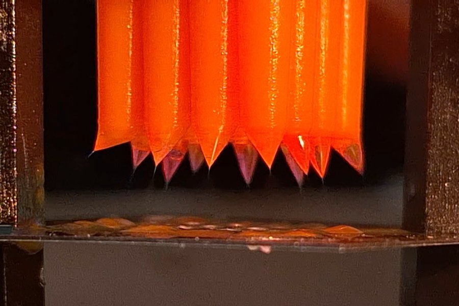 A zoomed-in view of nozzles that emit droplets.