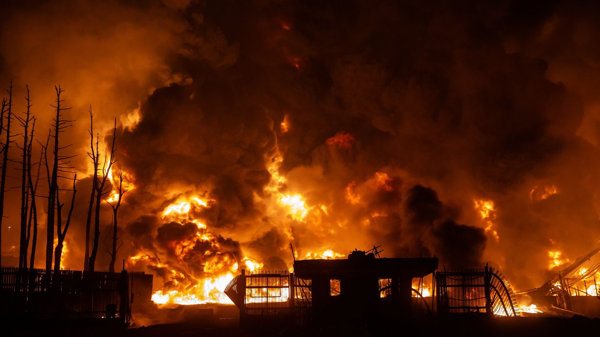 Bright orange flames and thick black smoke billow from the Shahran oil depot in Tehran following airstrikes.