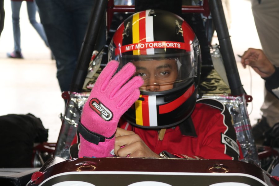 Close-up on the face of Faris Elnager in full racing gear, most of his face obscured by his helmet