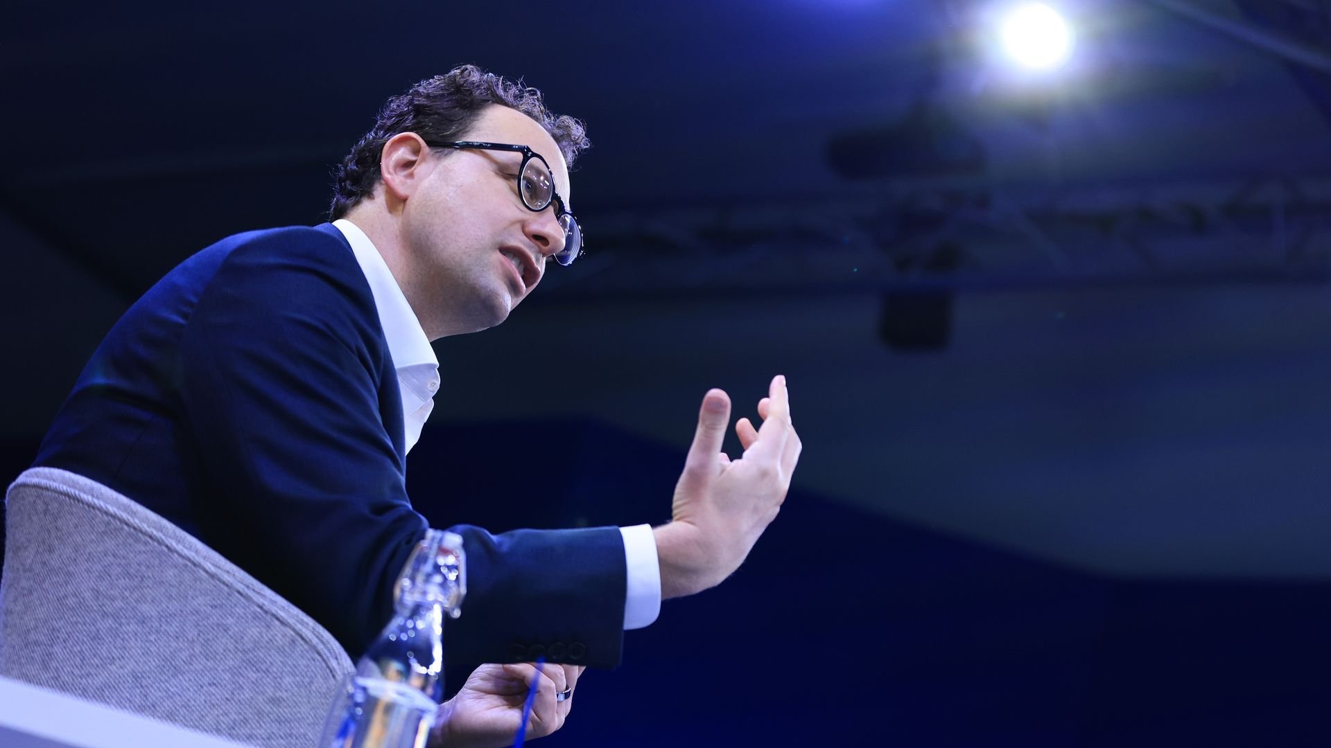 Man sitting in chair with hand raised at Davos in Switzerland