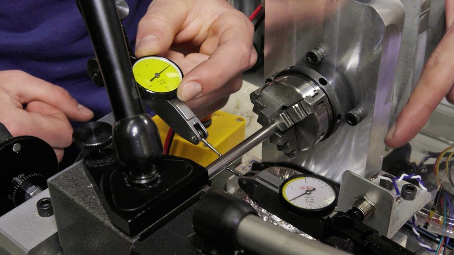 Closeup picture of hands adjusting a component on a lathe 