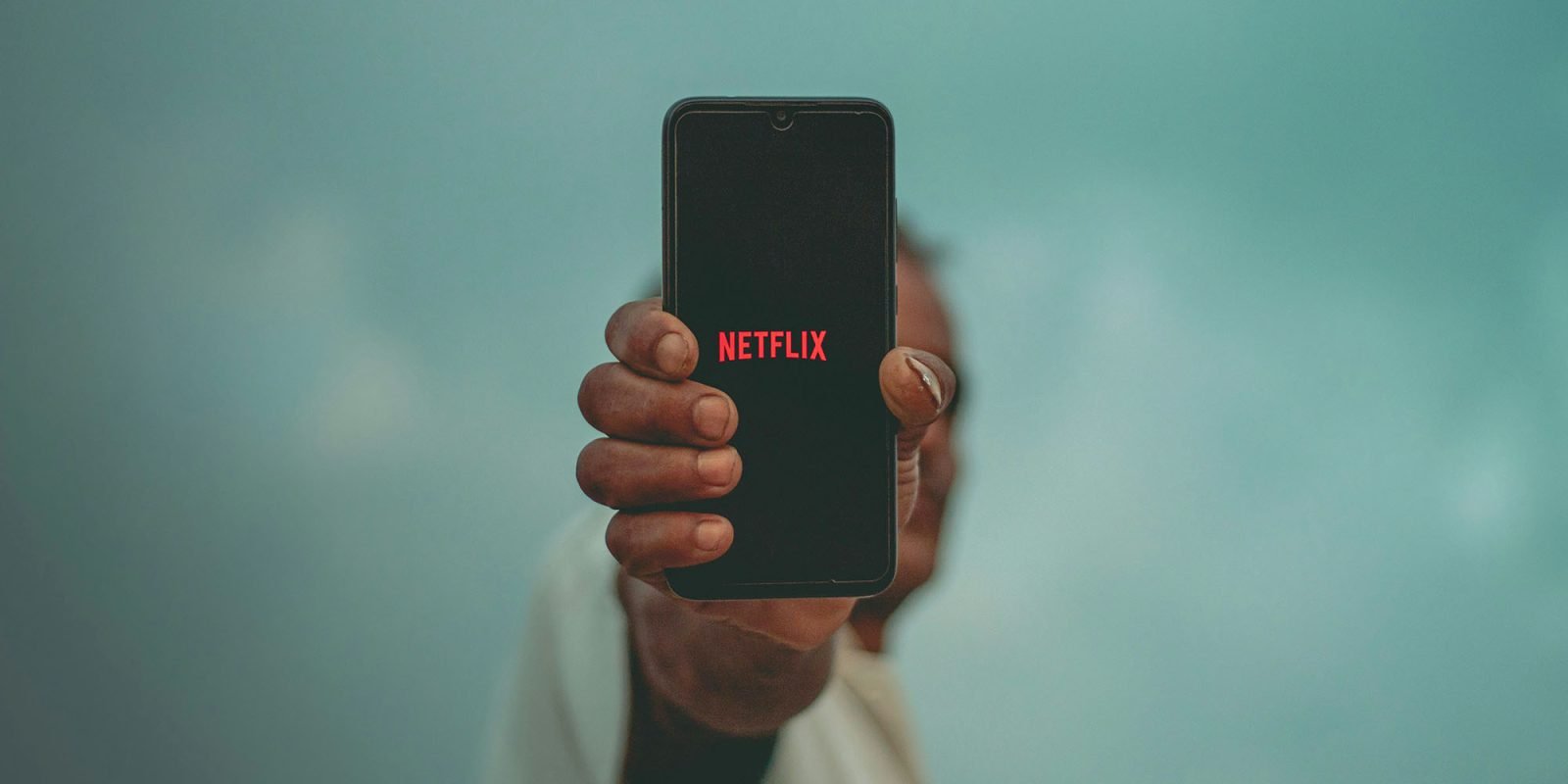 Netflix vertical video is coming this year | A hand holding a smartphone vertically with the Netflix logo on it