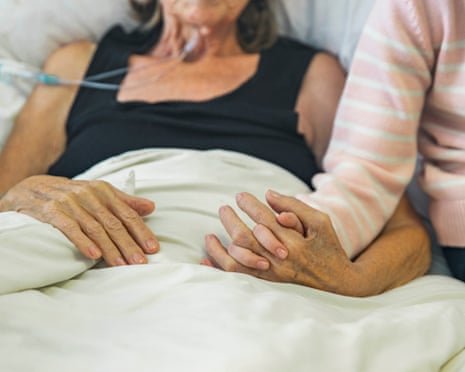 Young girl holds the hand of her ill grandmother