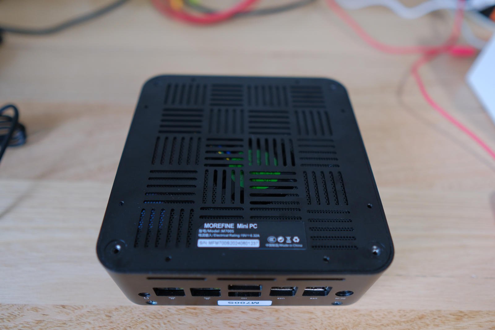 Photo of the underside of the M700S with the feet and screws removed. There's a four-by-four grid of slots cut into it with the slots alternating between vertical and horizontal. There is a mesh behind the slots.