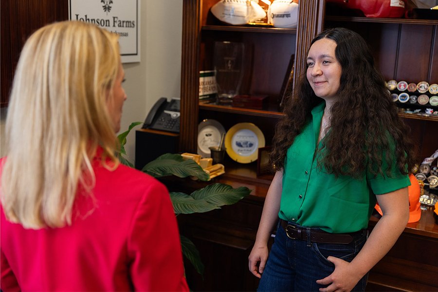Leslie Rutledge, with back to the camera, speaks with Kik Hayano in an office