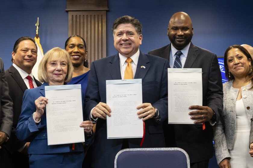 Flanked by supporters, Gov. JB Pritzker signs Illinois’ eighth consecutive state budget after a news conference in the Loop, Tuesday, June 16, 2026.