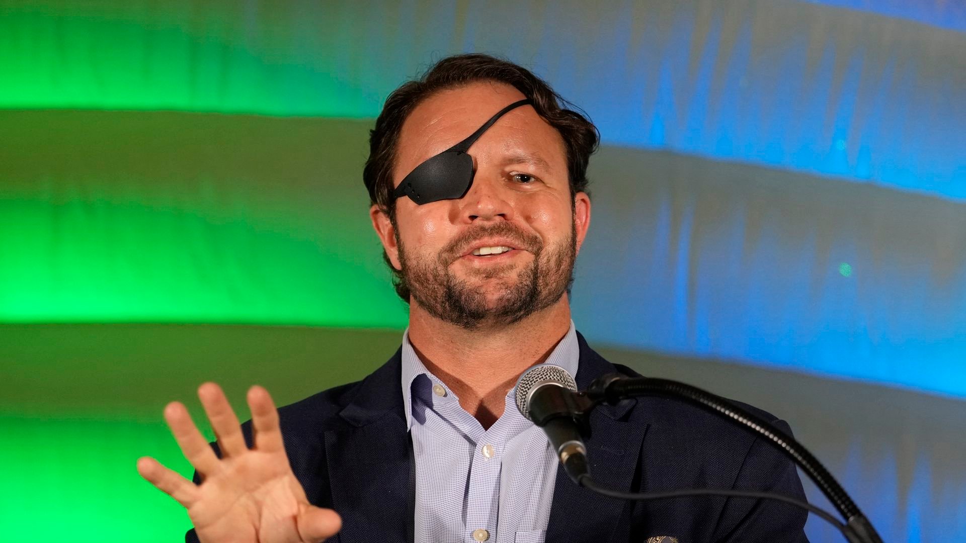Rep. Dan Crenshaw in front of a blue and green background