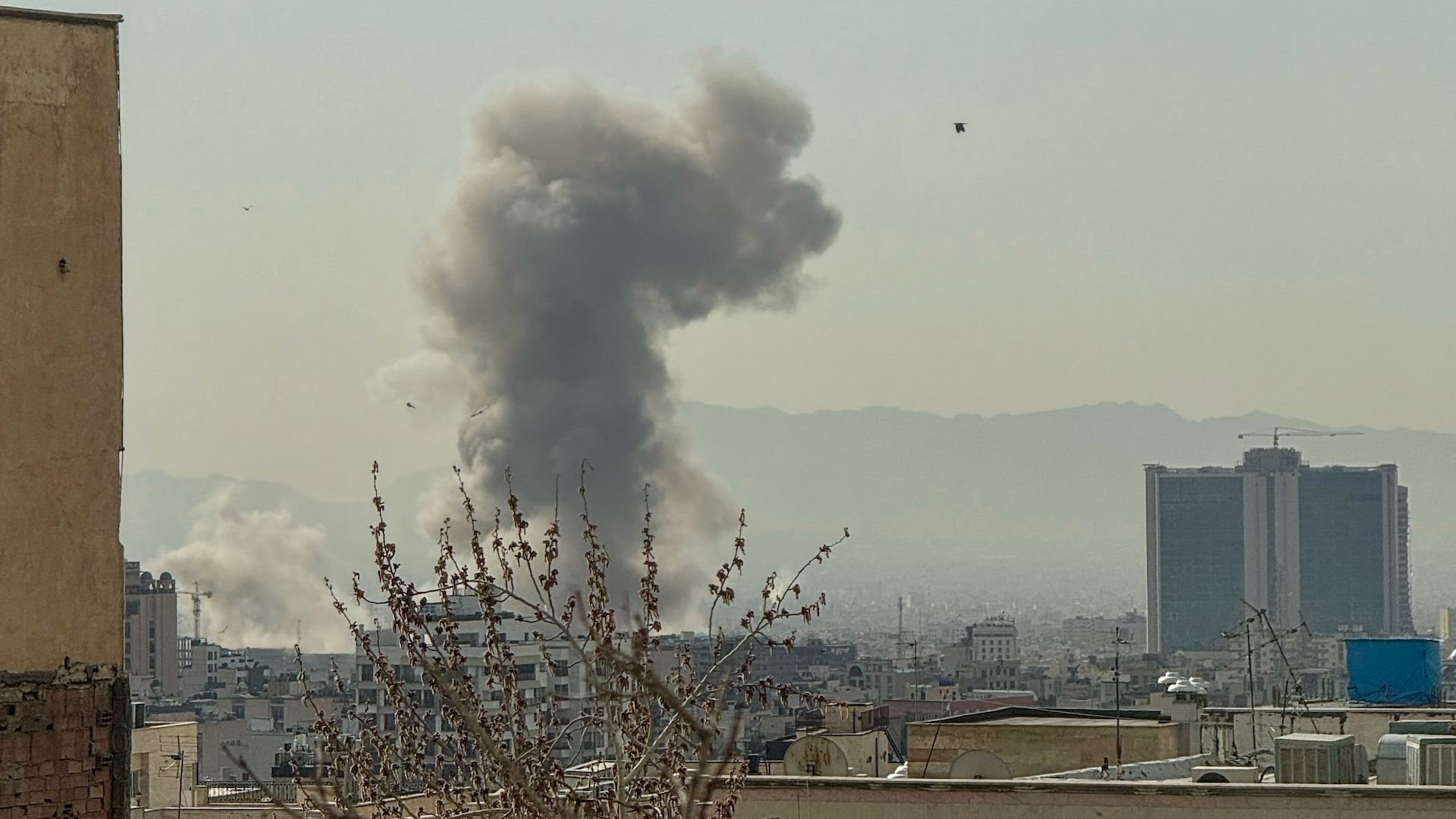 A plume of smoke rises over Tehran after a reported explosion on February 28, 2026