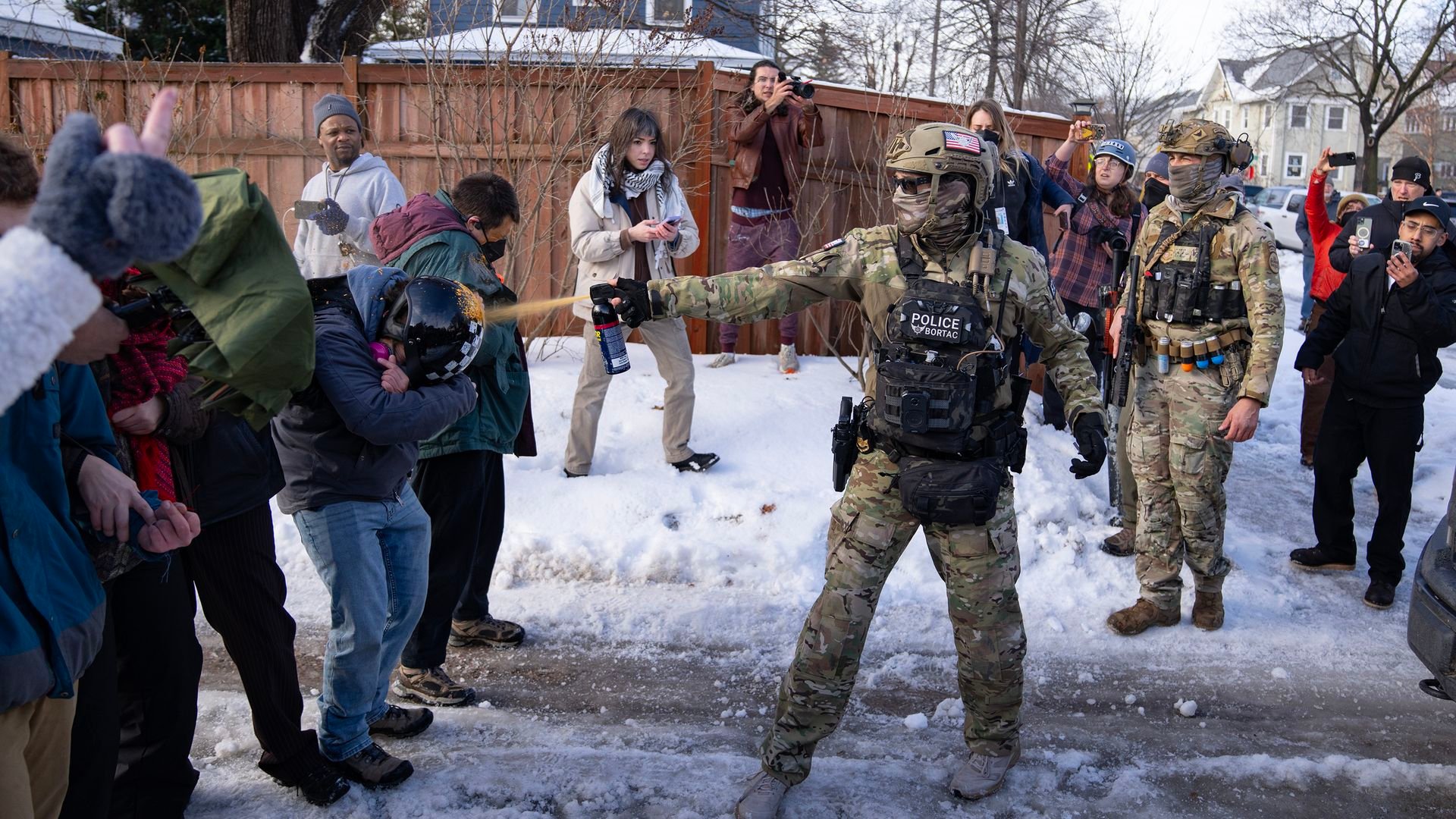 A Border Patrol Tactical Unit agent sprays pepper spray into the face of a protestor attempting to block an immigration officer vehicle from leaving the scene where a woman was shot and killed by a federal agent earlier, in Minneapolis, Minn. on Jan. 7.