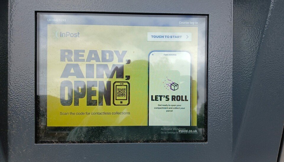 A parcel locker touchscreen shows a Windows activation warning beside an InPost prompt.