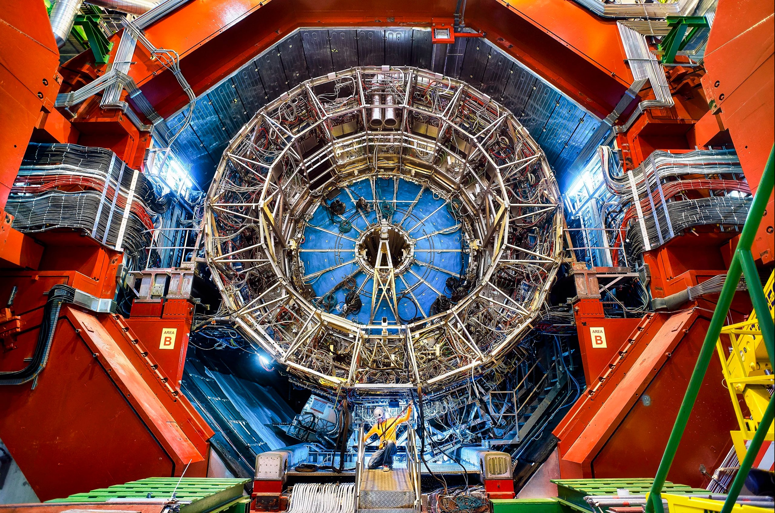 A large scientific instrument with radial symmetry, with a technician at the bottom.