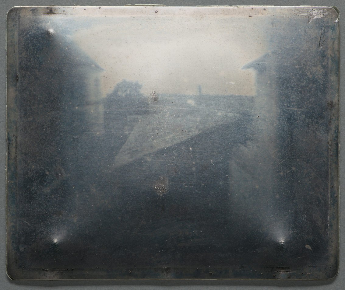 A ghostly image of rooftops, recorded on a polished metal plate.
