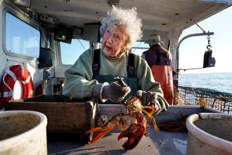 A woman with a lobster in hand.