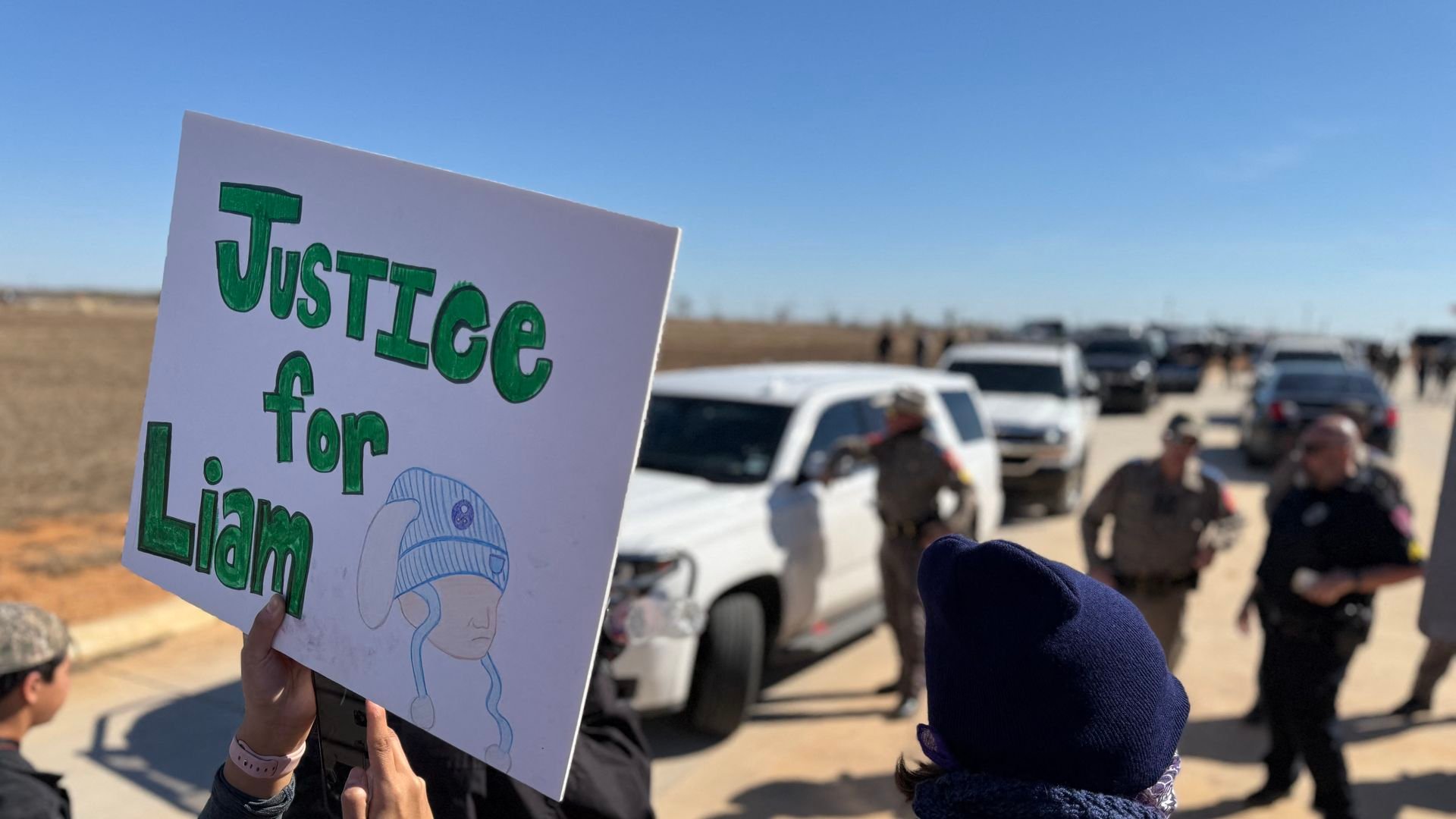 A person holds a sign that says 