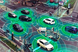 Cars at an intersection with futuristic sensors around them.