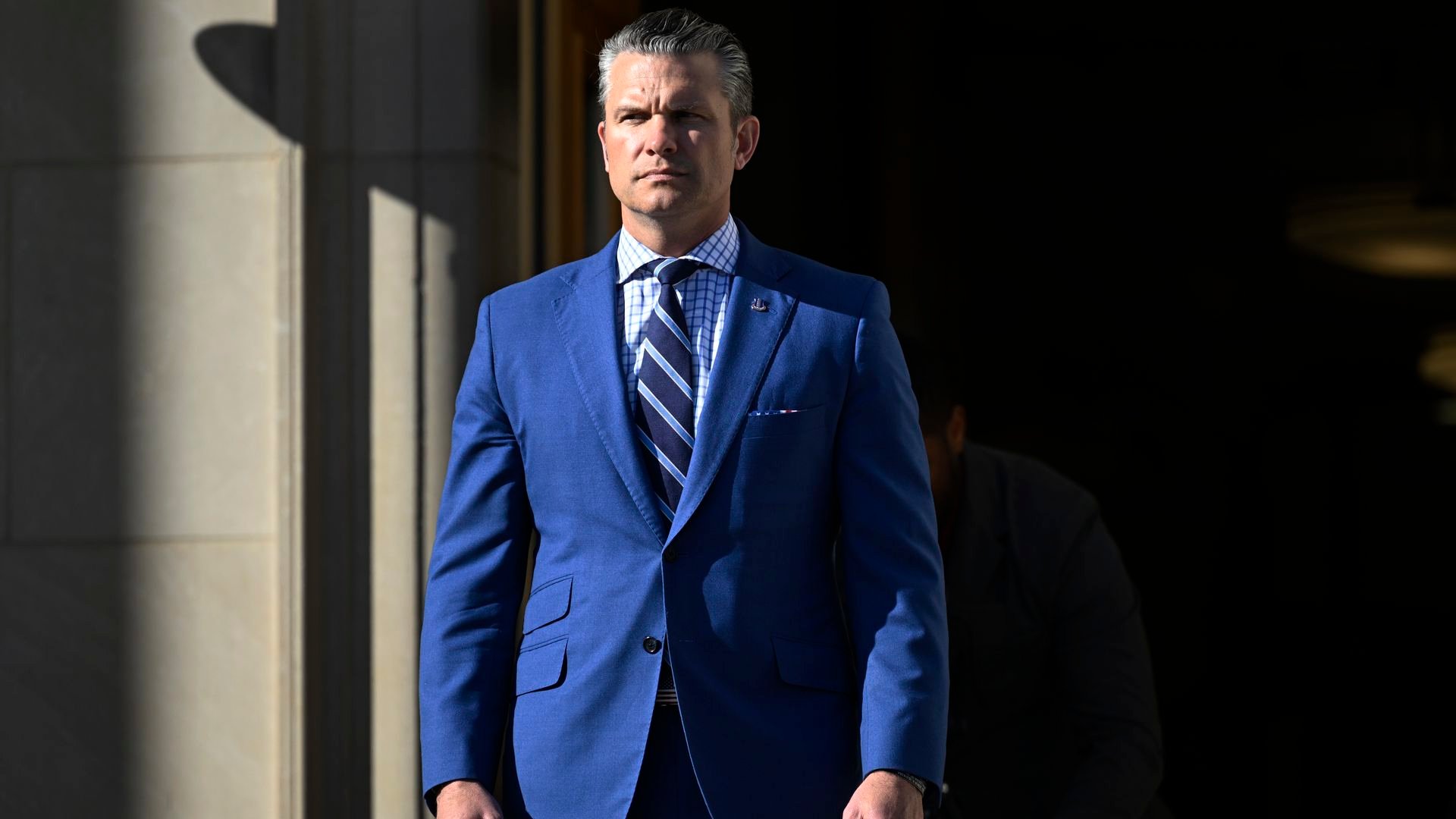 Hegseth suited and standing