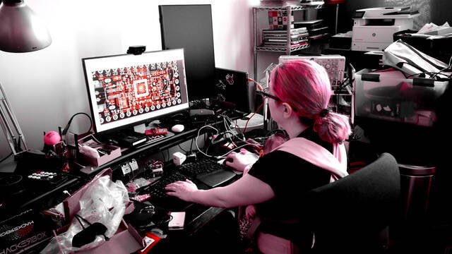 Image of Limor Fried and infant, at work designing open source hardware