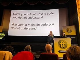 Jess and Eda on stage at FFConf in front of a slide that says 