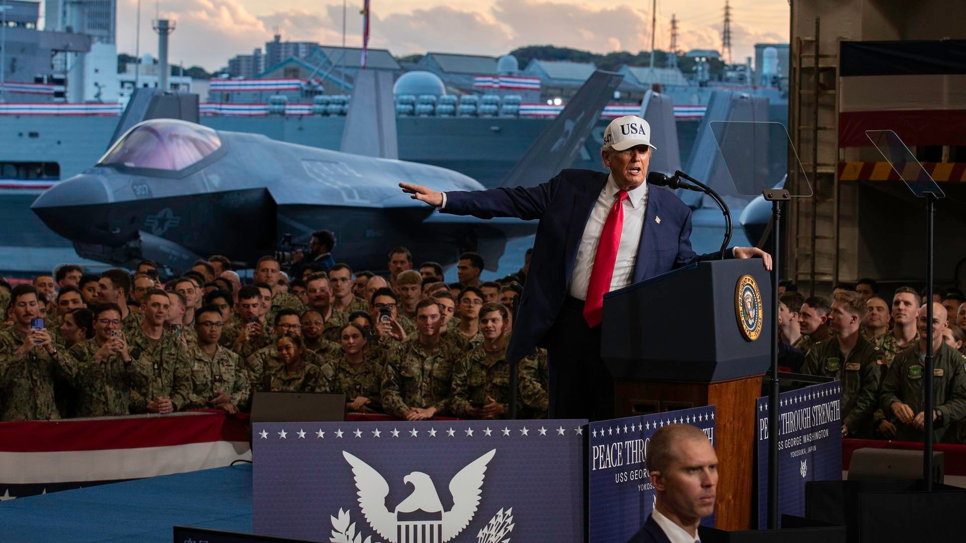A man in a suit and red tie wearing a white 
