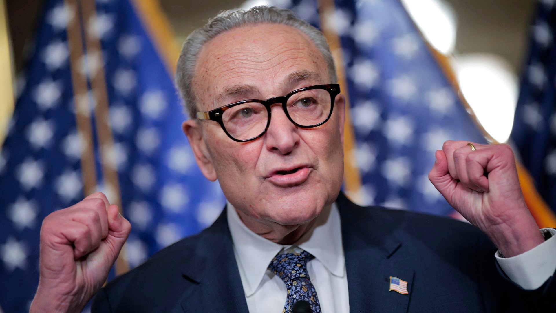Senate Minority Leader Charles Schumer stands at a podium with Senate Democrats during a news conference at the U.S. Capitol.