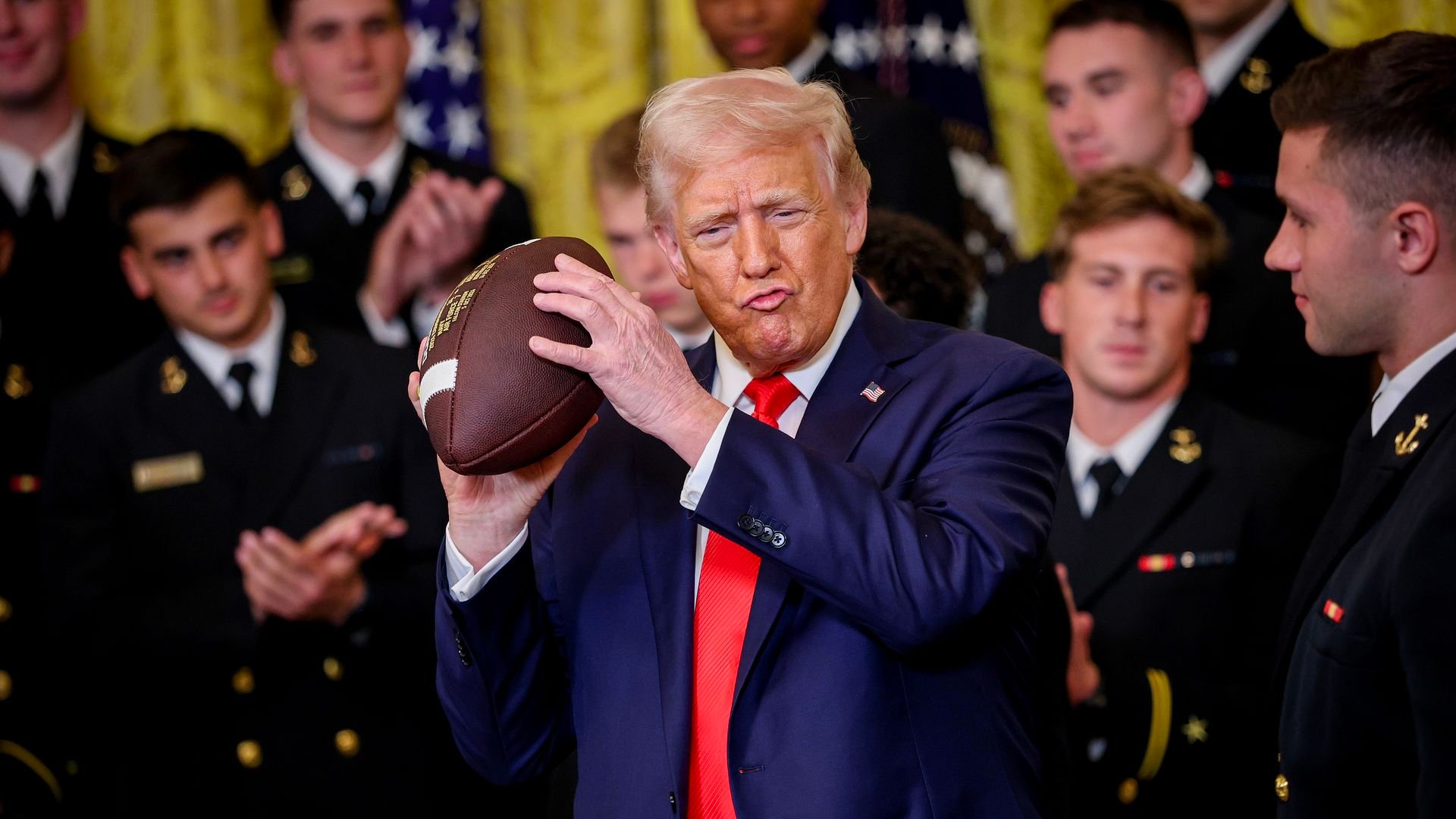 President Donald Trump holds a football alongside Navy Midshipmen linebacker Colin Ramos during the Commander-in-Chief Trophy presentation at the White House in Washington, D.C., on April 15, 2025.