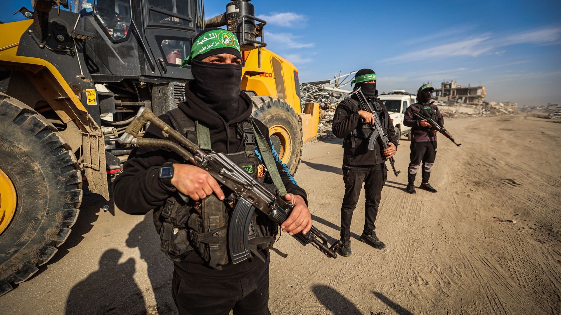 men in hamas outfits near a bulldozer