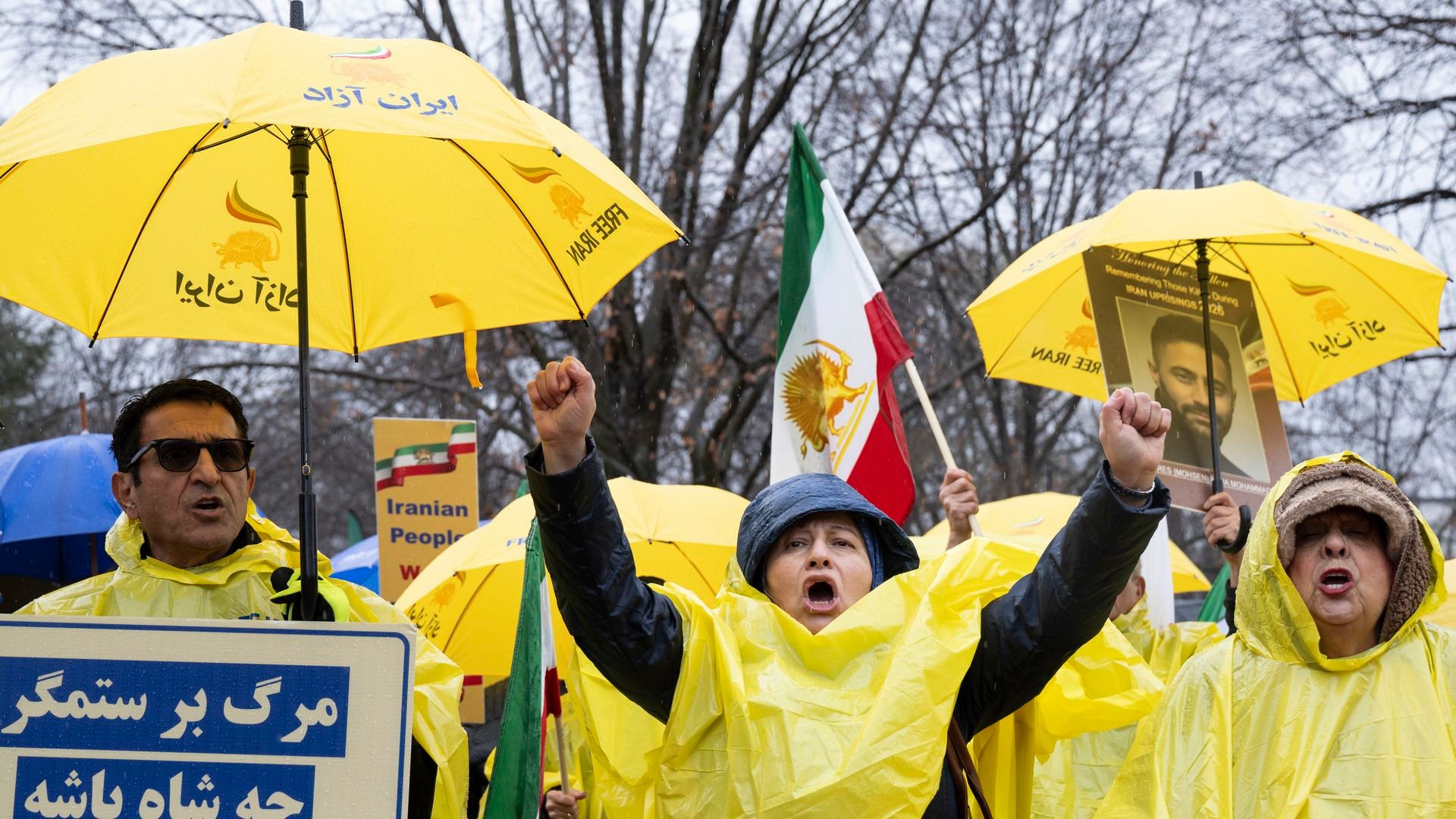 Protesters in yellow ponchos holding yellow umbrellas and signs