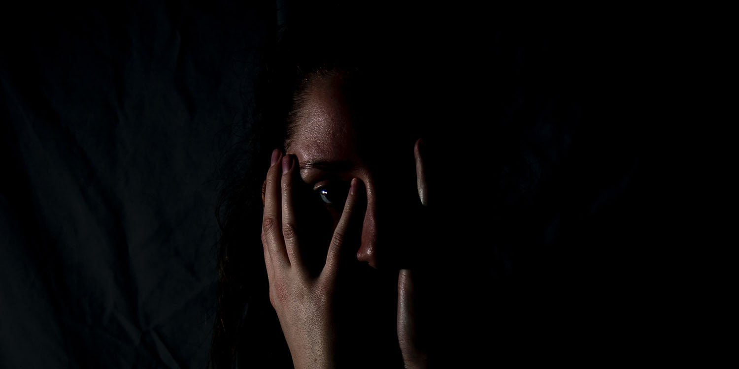 Two countries block Grok app over AI-generated CSAM as we await Apple's response | Frightened woman in the dark