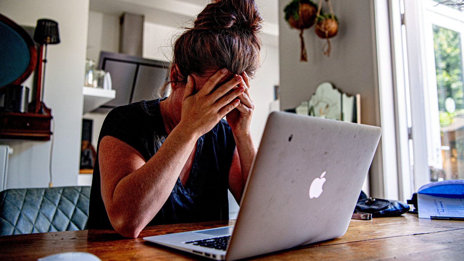 Woman looking stressed at her laptop.