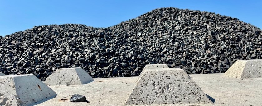 Pile of rocks looming behind a concrete wall