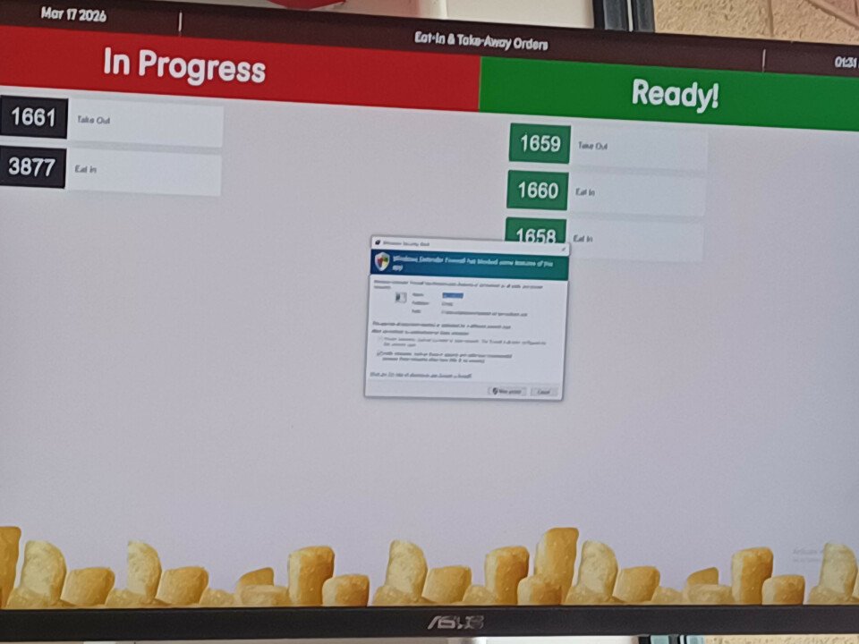 A Windows Defender Firewall warning is displayed on a restaurant order progress screen above a row of fries.
