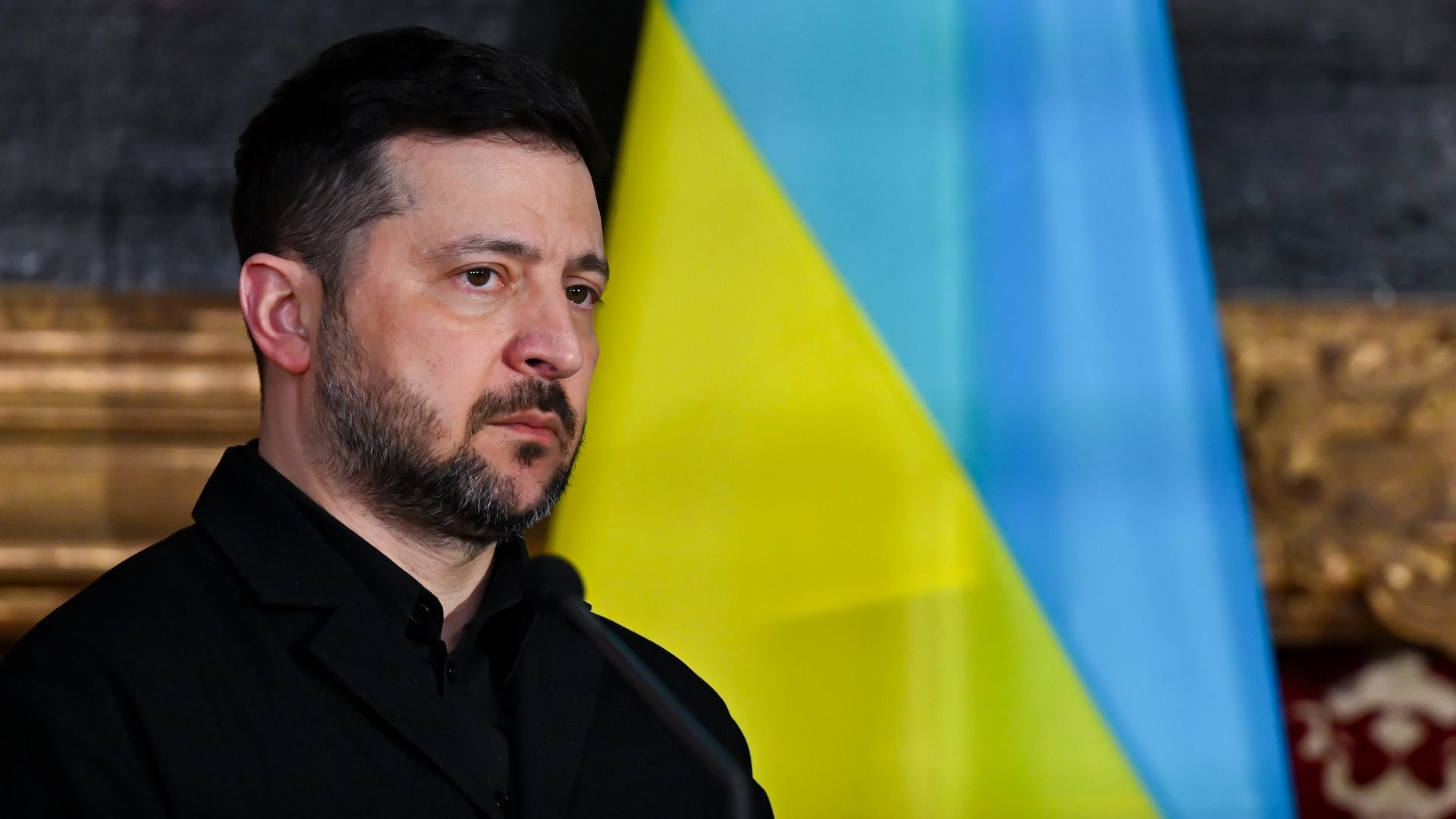 Zelensky in front of a flag